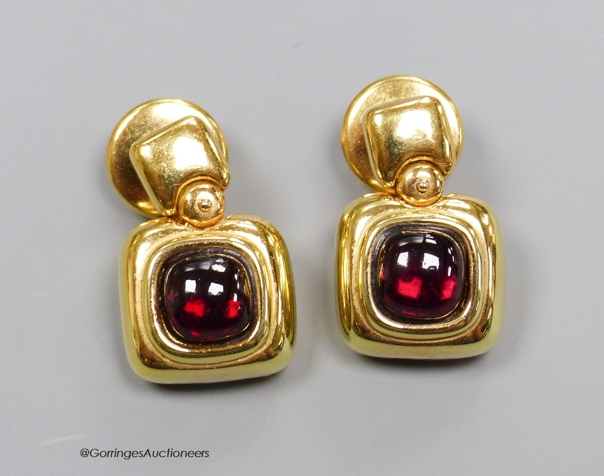 A pair of '750' and cabochon garnet earrings, gross 10g.